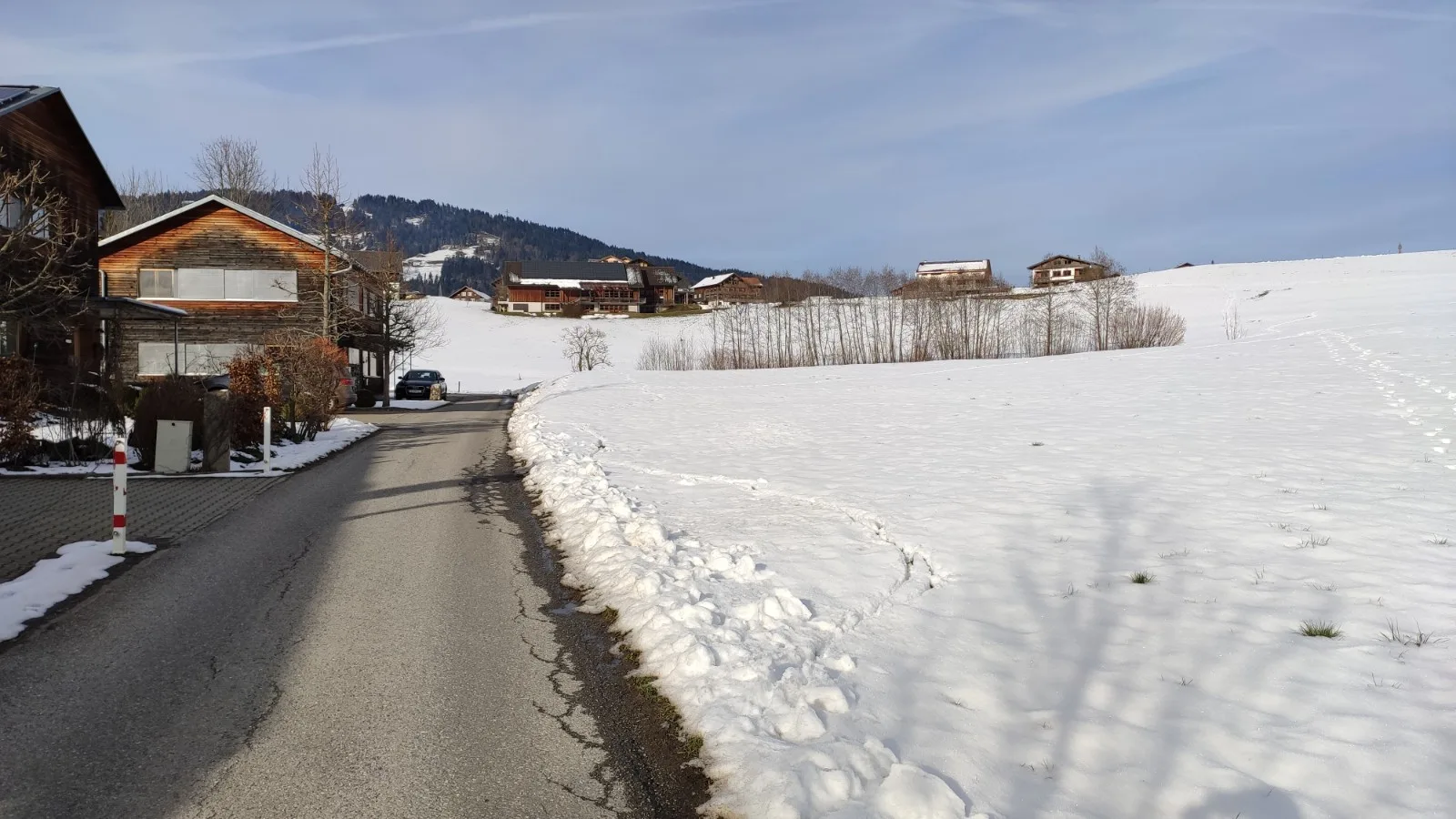 Die Zufahrt nach Moos im Winter, der Hof am linken Bildrand