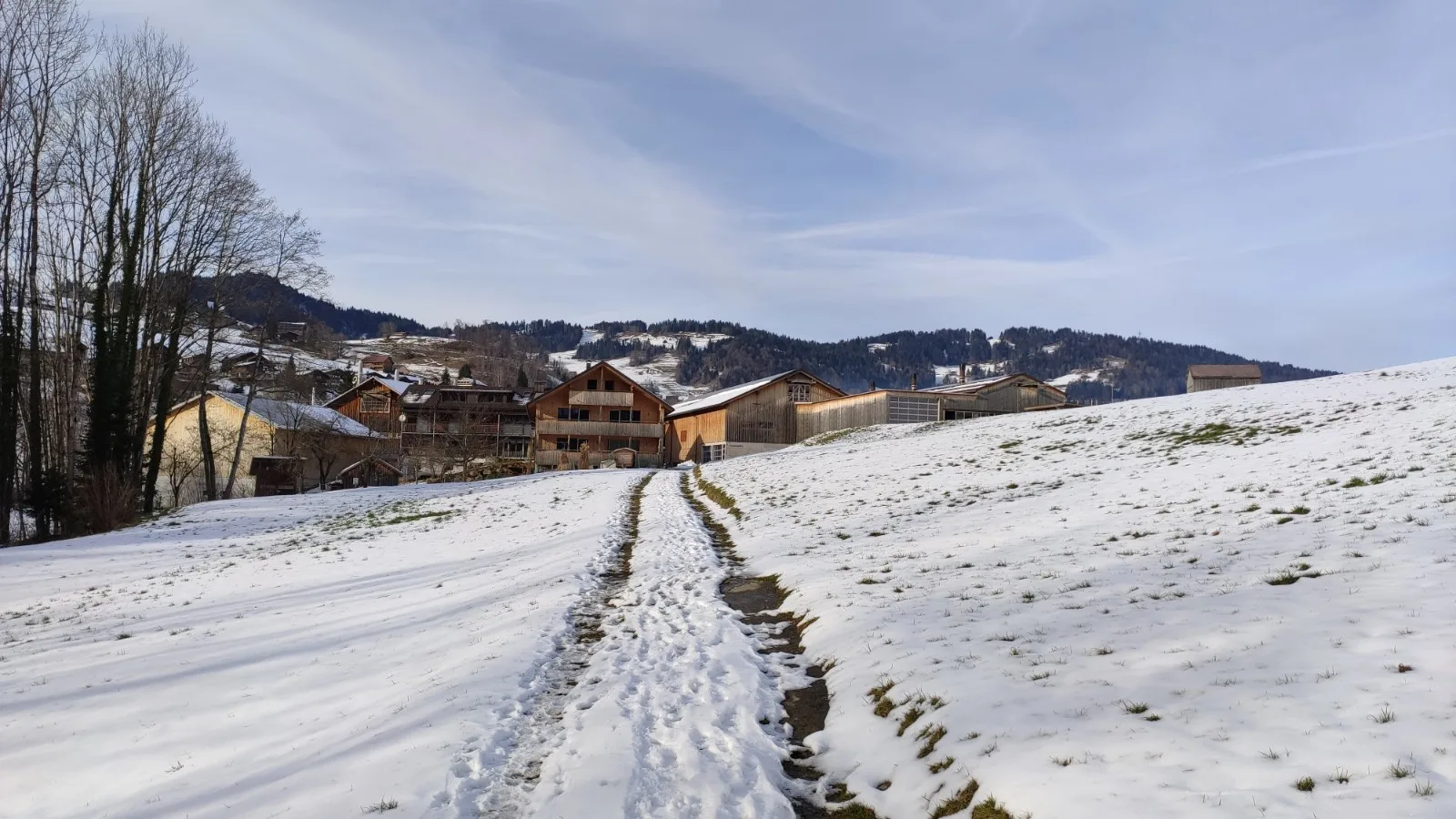 Das Hofensemble im Winter, von der verschneiten Wiese aus gesehen