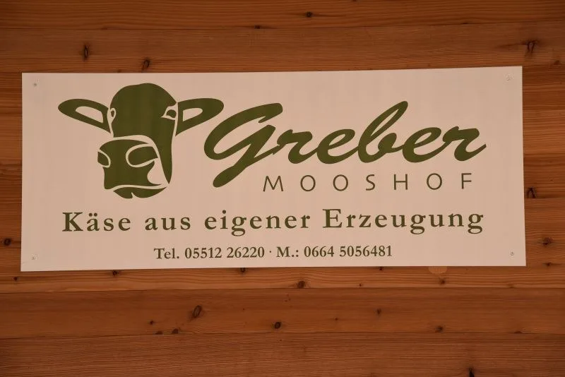 Schild am Hofladen: Greber Mooshof, Käse aus eigener Erzeugung, mit beiden Telefonnummern